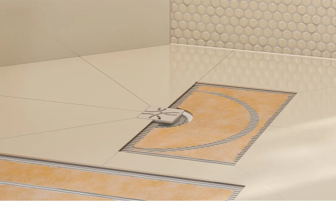 Tiled shower floor with a square drain grate, the orange waterproofing membrane showing under the cut-away tiles